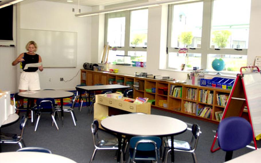 A first-grade teacher prepares a bulletin board for the first day of school.