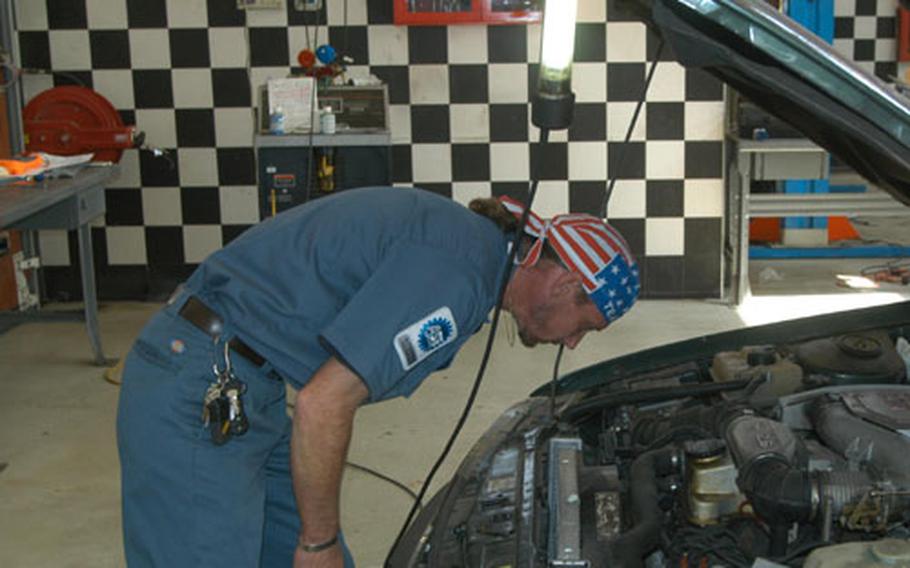 Howie Overacker, one of three employees at Vicenza's auto skills center, looks at a car brought into the shop Wednesday. The center has been selected as the Army's best medium-sized facility for 2004.