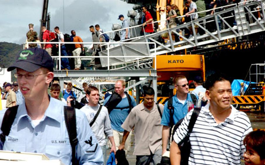 USS Kitty Hawk carrier strike group sailors leave the ship earlier this week after completing a two-month underway period in the western Pacific Ocean.