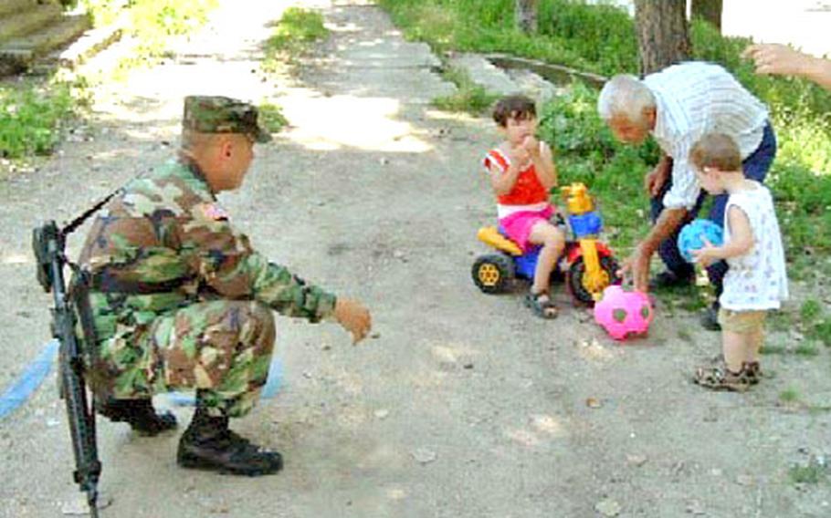 Spc. Doug Bullock plays ball with some of his neighbors in Valsenica. He is among the members of the Indiana National Guard living in a house in the Serb area of country.