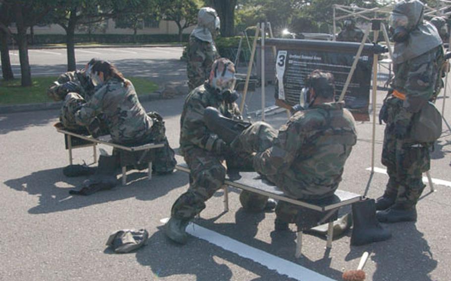 More than 30 Yokota airmen process through a decontamination line Thursday during the wing's Operational Readiness Exercise at Yokota Air Base, Japan.