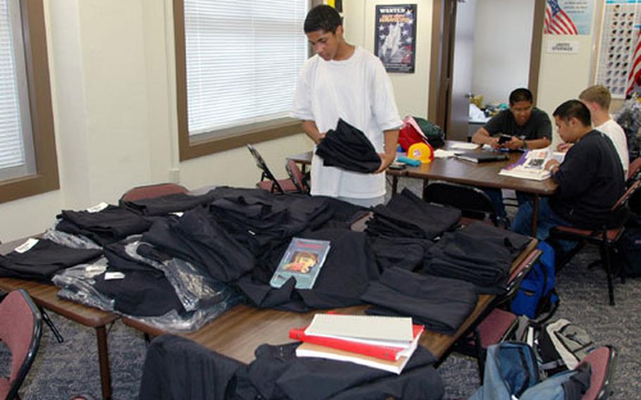 Byrrh Bryant, a 9th grade student in the Navy Junior Reserve Officer Training Corps at Sasebo Naval Base's Ernest J. King High School, looks for uniform pants in his size Thursday as JROTC cadets were fitted for their uniforms.
