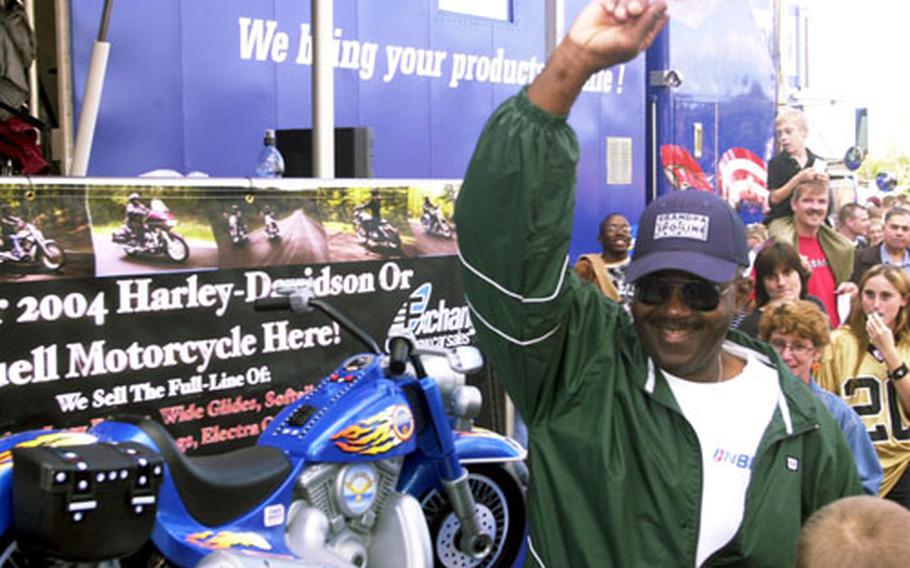 Tech Sgt. John Green, a cargo specialist with the 38th Aerial Port Squadron, comes forward waving the winning ticket stub to claim his new Harley-Davidson motorcycle Sunday afternoon in Vogelweh, Germany.
