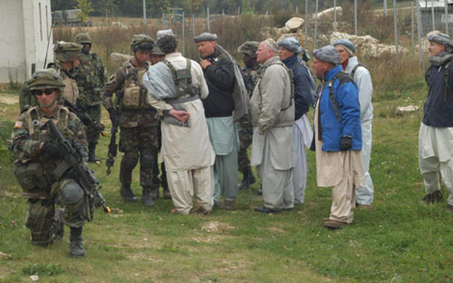 Soldiers from Southern European Task Force’s 173rd Airborne Brigade interact with role players in Afghan garb Wednesday at the Combat Maneuver Training Center in Hohenfels, Germany. The 173rd Airborne soldiers were gearing up for a mission rehearsal exercise for their deployment to Afghanistan next spring.
