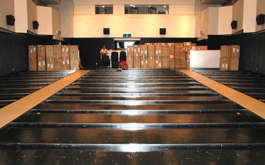 Sasebo Naval Base Morale, Welfare and Recreation department employees wait Tuesday afternoon to begin unpacking the new theater chairs being installed at the Showboat Theater.