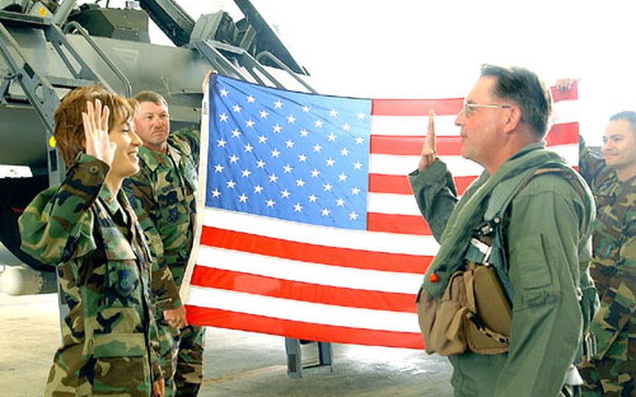 2nd Lt. Sherry Mattson, left, a contracting officer for the 374th Airlift Wing, gives the oath of enlistment to her father, Chief Master Sgt. Brett Allison, 35th Operations Group, Monday at Misawa Air Base.