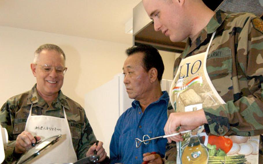 Maj. Richard Bendorf, left, chaplain for the Army's Area IV in lower South Korea, gives some cooking pointers Friday to Kim Man-cho, center, and Pfc. David White at the Soldiers Memorial Chapel on Camp Walker in Taegu, South Korea. Both Cho and White work with the chapel program. Bendorf, known also as “The Frian’ Friar,” plans to publish a cookbook with favorite recipes.