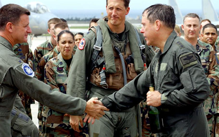 Lt. Gen. Thomas C. Waskow, right, commander U.S. Forces Japan and 5th Air Force, shakes hands Friday with Col. David Freaney, 18th Wing Operations Group commander, after Waskow’s final flight in an F-15, as Lt. Col. Jeff Gustafson, the 67th Fighter Squadron commander, looks on.