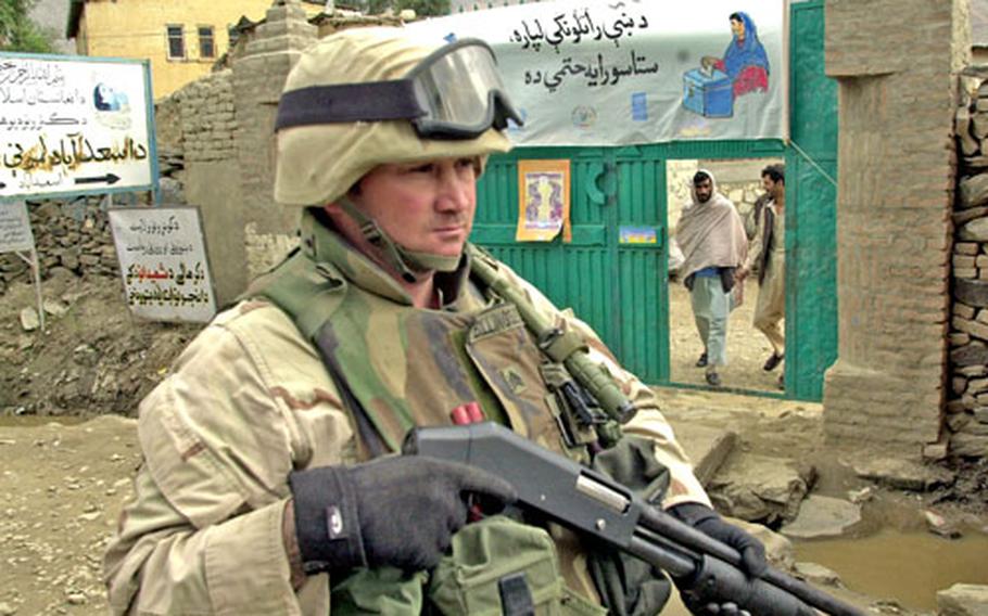 Sgt. Michael Billingsly, 125th Signal Battalion, 25th Infantry Division, passes Asadabad's main polling station while on patrol during Saturday's voting.