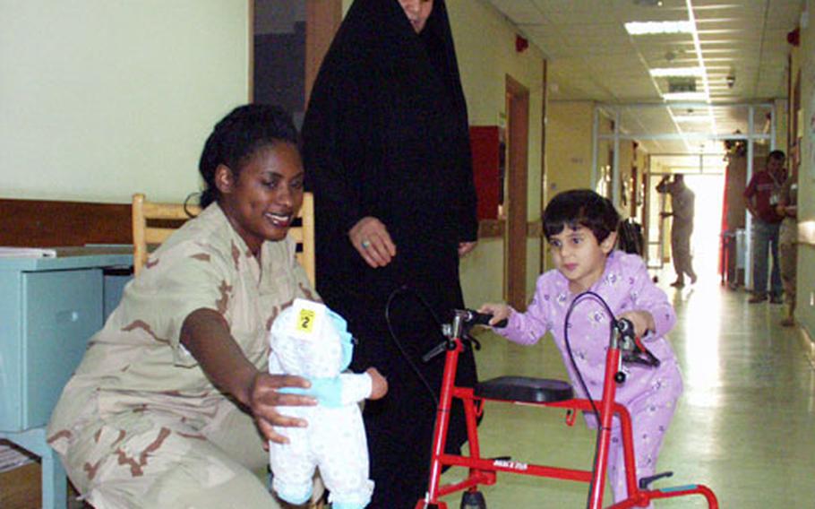 Capt. Leslie Goodwin, an intensive care nurse at the Army hospital in Baghdad, helps Dihar Aljazy, 5, learn to walk again after bandits shot her in the back. Her grandmother, Jammala, center, says Americans “deserve more gratitude from our side.”