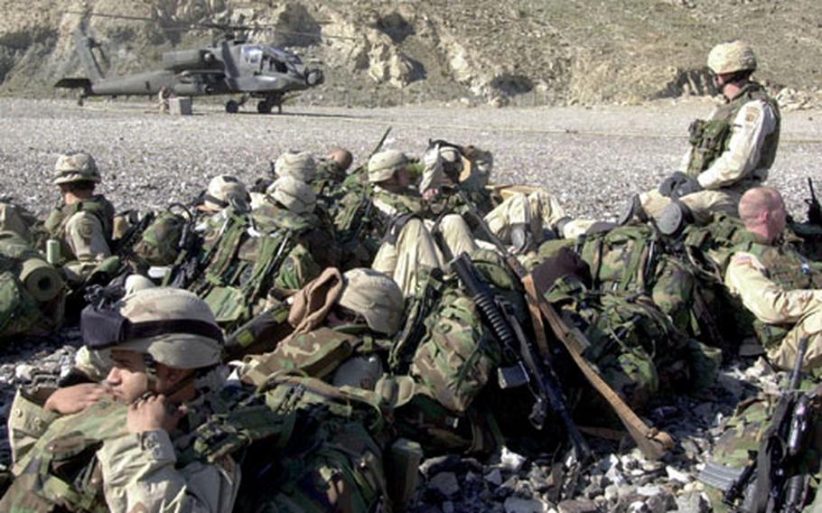 Soldiers with the 82nd Airborne relaxed in the early morning sun Friday while an AH-64 Apache refueled at Firebase Asadabad. The attack helicopter escorted the CH-47 Chinook helo which inserted about 60 soldiers onto an 8,000-foot ridge for an air-assault mission near the Pakistan border.