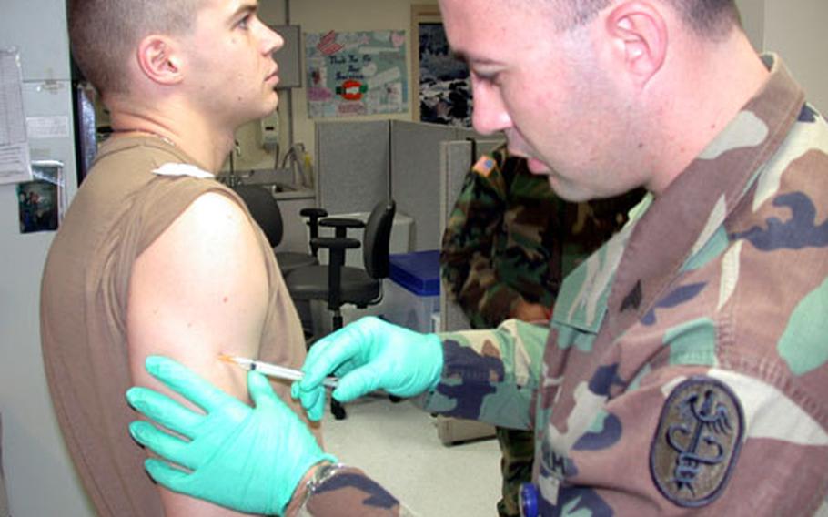 Sgt. Scott Johnson, 29, gives an anthrax vaccination booster shot to Sgt. Jeremy Stanton, 26, at the DiLorenzo Tricare Health Clinic at the Pentagon. All servicemembers have until Dec. 31 to get caught up on their anthrax vaccine shots.