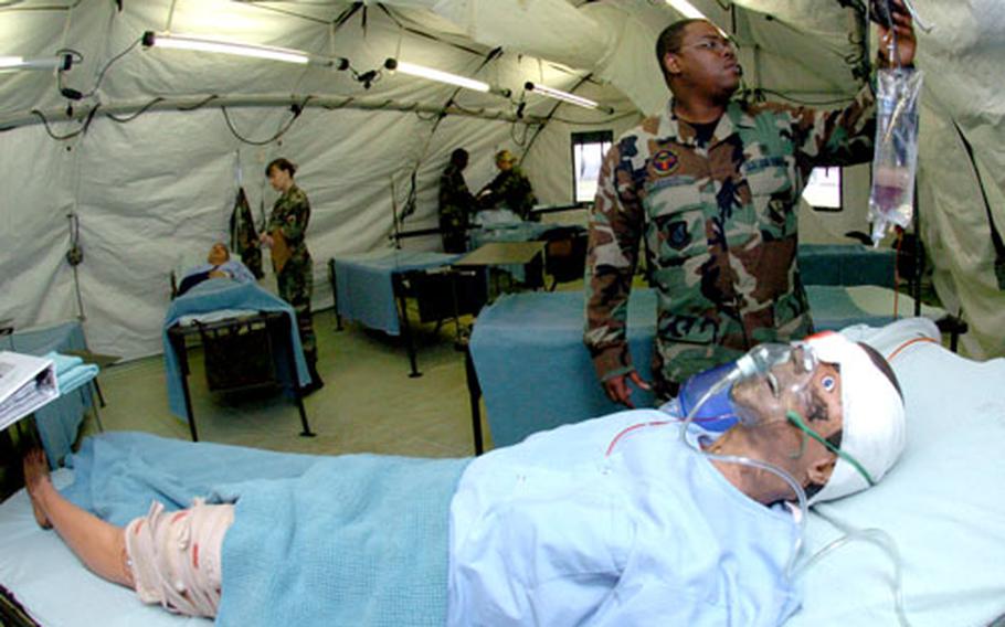 Airman 1st Class Jonathan Bowie, medical technician, works with a training dummy during a demonstration of the Expeditionary Medical Support system Wednesday at Yokota Air Base, Japan.