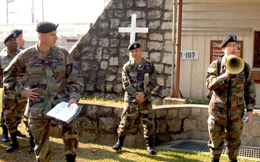 Area One commander Col. Jeff Christiansen, left, listens while a member of the 2nd ID chaplaincy explains what will happen to the Camp Gary Owen chapel when the base closes later this year.
