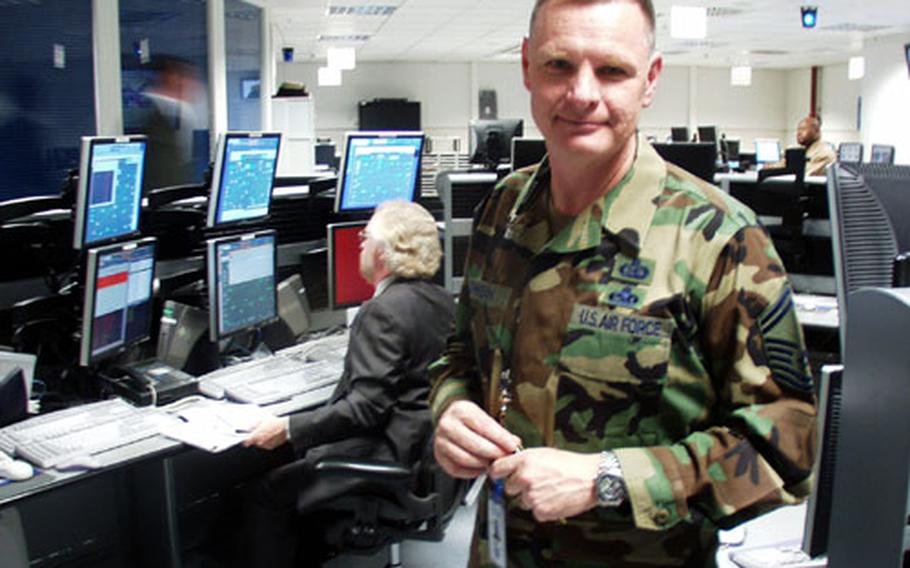Senior Master Sgt. Alan S. Johnson stands in front of a bank of new computers at the new Regional Network Operations and Security Center at the Defense Information Systems Agency in Stuttgart, Germany.