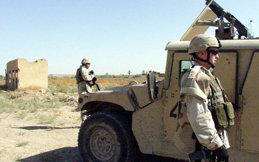 Army Sgt. Patrick Castillo, left, and Spc. James Yauger look for insurgents in likely mortar positions in Iraq's Abu Ghraib area Friday morning.