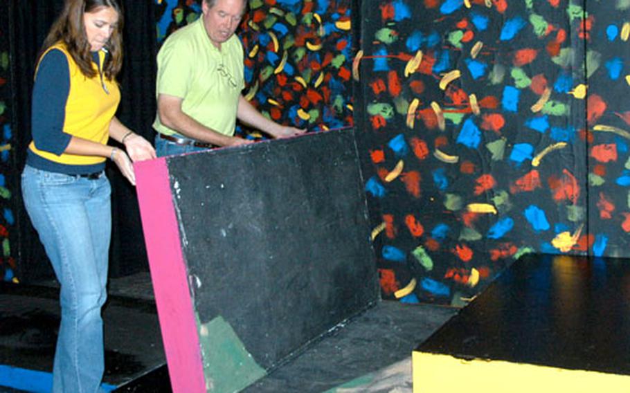 Jack Austin, right, and Mary Berry, theater specialist, work on the set of a high school production that was painted by school volunteers Monday at Bamberg's Stable Theater.