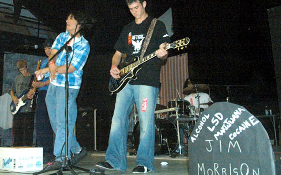 Members of Hatchetboy 888, a band of Naples High School students, perform during an anti-drug concert after school Wednesday. Lining the stage was a chain of red links with names of students who pledge to be drug-free and tombstones of famous musicians who’ve died because of drugs or alcohol.
