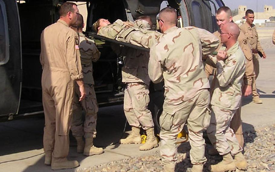 Sgt. 1st Class David Dennis, left, with the 82nd Medical Company (Air Ambulance), shows students how to properly load a patient in a Black Hawk during a Combat Lifesavers training class earlier this month at LSA Anaconda, Iraq.