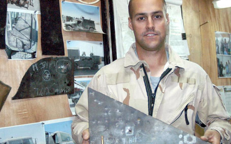 Spc. Scott LaClair, a welder and maintenance technician for the 7th Transportation Battalion’s Skunk Werks, holds a piece of Armox ballistic steel shot up by Explosive Ordnance Disposal soldiers at Anaconda. The only hole was shot seven times in the same spot.