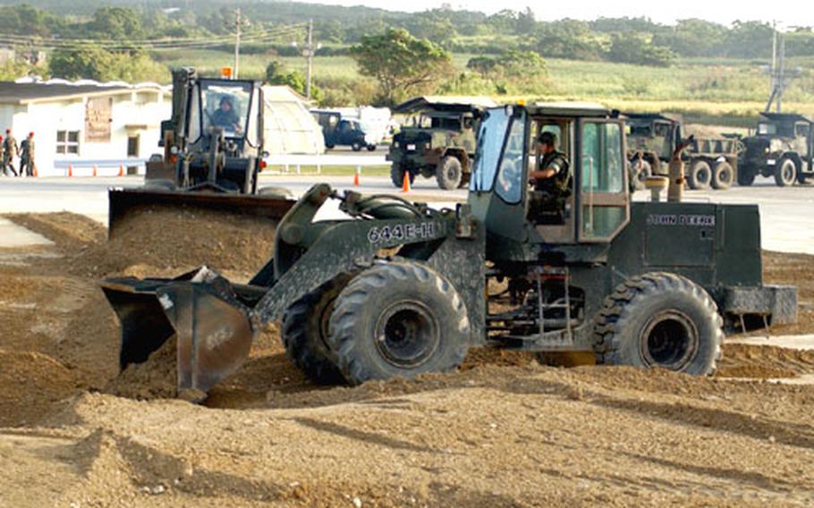 Marine Wing Support Squadron 172&#39;s team fills in the 50-foot wide by 20-foot deep hole during the airfield runway repair competition held on Kadena Air Base last week. The team took first place in the competition, narrowly edging out the Air Force and Navy team.