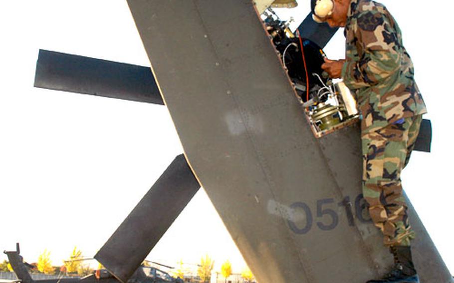 Staff Sgt. Darius Lazare, 34, of St. Thomas, Virgin Islands, services the tail rotor on an Apache helicopter.