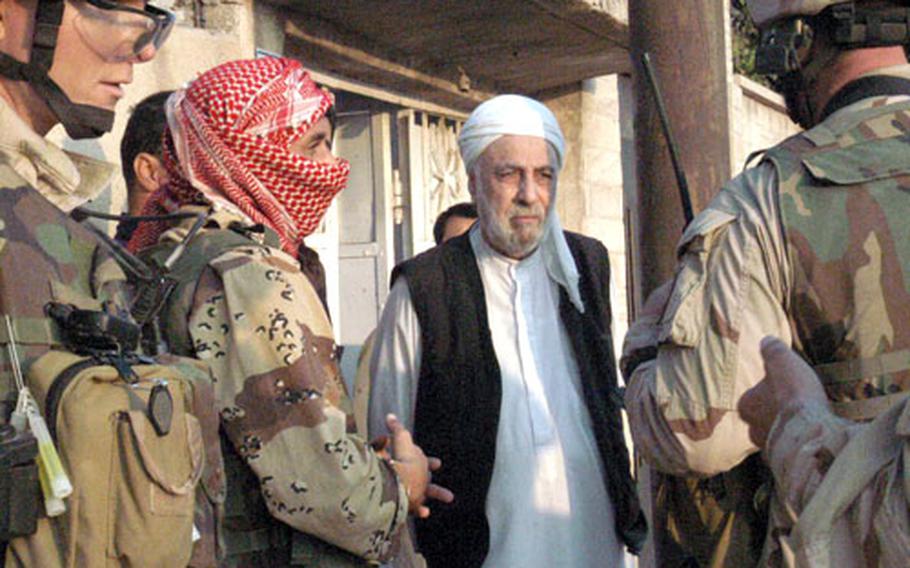 Lt. Col. Erik Kurilla, right, speaks to the resident of a house during a cordon-and-knock mission in Mosul, Iraq. For the mission, U.S. and Iraqi forces systematically check out a neighborhood looking for enemy forces or illegal weapons, but do so without building animosity. “Rather than kick the door and make everybody upset, we knock and ask permission to come in,” says Capt. Matthew McGrew.