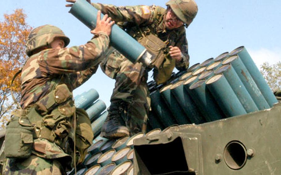 Pfc. Steven Meier, 20, right, and another U.S. soldier load cannisters into a Volcano mine-laying system.