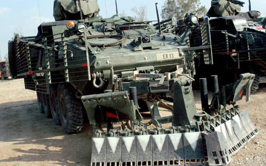 Engineer Support Variant Strykers, with a front sweeping apparatus, plow along roadsides and find explosives before a convoy does.