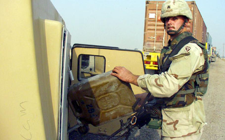 Sgt. Austin "John-o" Williams refuels his Humvee during a break in the Iraqi Express convoy.