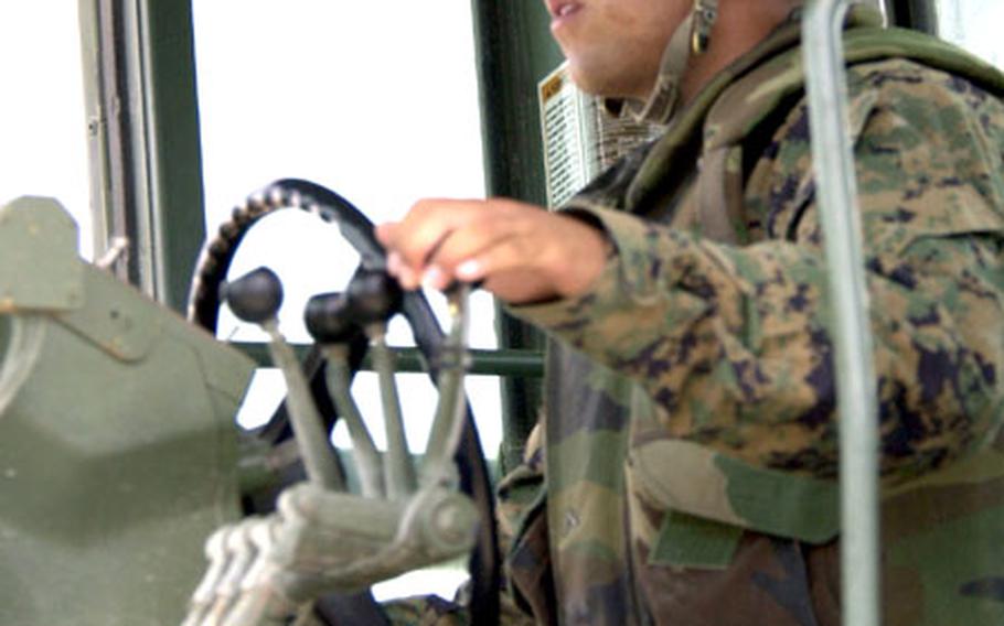 Marine Pfc. Fernando Espinosa, from Marine Wing Support Squadron 171, drives a construction grader while working on resurfacing the coral runway on Ie Shima.