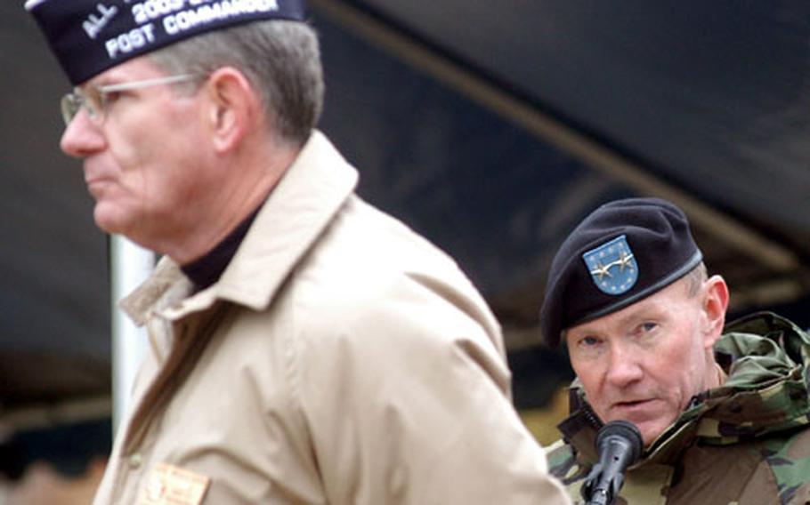 Joe Mulligan, commander of Wiesbaden&#39;s Veterans of Foreign Wars Post 27, left, listens as 1st Armored Division commander Maj. Gen. Martin E. Dempsey speaks at the Veterans&#39; Day ceremony at the Wiesbaden.