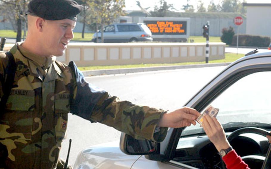 Spc. Aaron Stanley, of Battery B, 1st Battalion, 134th Field Artillery Regiment of the Ohio National Guard, checks an identification card Tuesday at Aviano Air Base, Italy. The 470-member contingent is set to leave Europe at the end of the month and won’t be replaced by another guard rotation.