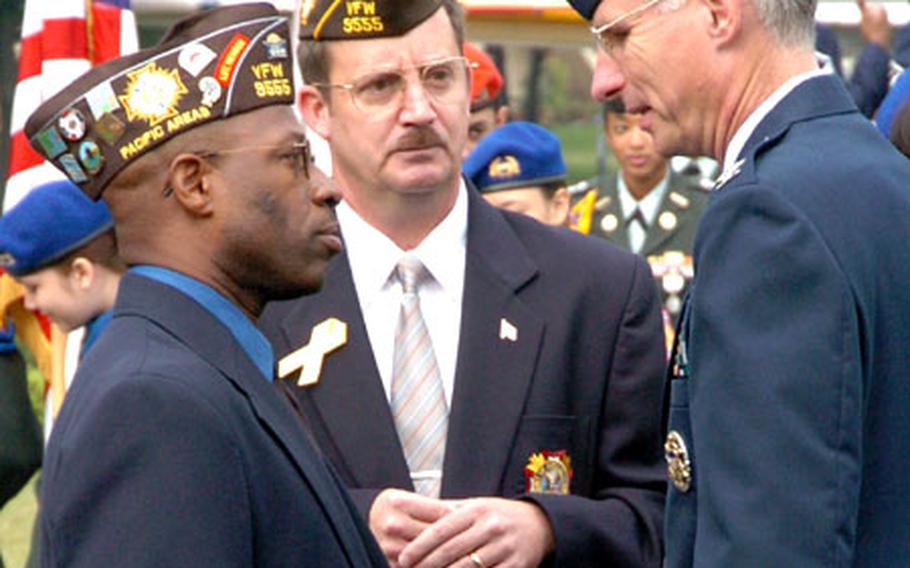 Col. Mark Schissler, right, 374th Airlift Wing commander, chats with Kevin Mitchell, left, and Anthony Byrd of the Veterans of Foreign Wars Post 9555 during a Veterans Day ceremony Thursday at Yokota Air Base.