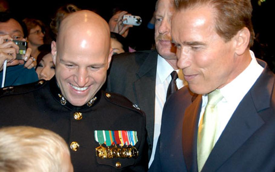 California Gov. Arnold Schwarzenegger, left, greets Capt. Jeff Petersen (at left, in uniform) of Atsugi Naval Air Facility, Japan, and Dustin Wyrick (foreground) during the Marine Security Guard Detachment Tokyo&#39;s Marine Corps Ball Friday night.