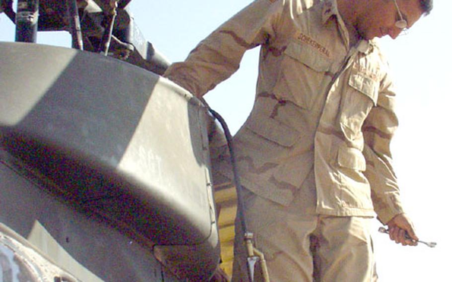 Sgt. Luis Scheker, 28, of the 601st Cavalry Support Detachment, reaches for a tool while working on the engine of an OH-58 Kiowa Warrior at Forward Operating Base MacKenzie near Samarra, Iraq. He is one of about 400 soldiers who will have to leave Europe next year when the 1st Infantry Division and 1st Armored Division lose their OH-58s to the Hawaii-based 25th Infantry Division and the New York-based 10th Mountain Division.
