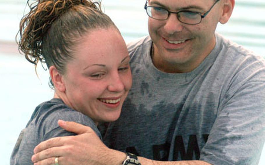 Spc. Audrey Griffiths smiles and hugs Chaplain (1st Lt.) Dan Langston after he baptized her at LAS Anaconda.