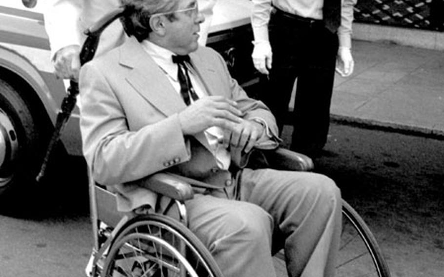 At age 87, Col. Harland Sanders was still nimble enough to assist Robert Hardy, Kentucky Fried Chicken's director of operations for the Middle East and Africa, in front of Tokyo's Okura Hotel in June, 1978.