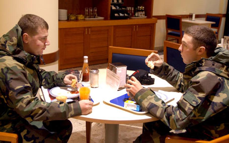 Airman Chris Evans, left, and Airman 1st Class Bryan Nelson sample the debut of breakfast Tuesday at the La Dolce Vita dining facility at Aviano Air Base in Italy.