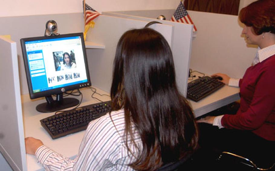 Melenie Evans and Laryn Hernandez, Army Community Service Center employees, test two of the four computer terminals in the Yellow Ribbon Room in Darmstadt, Germany.