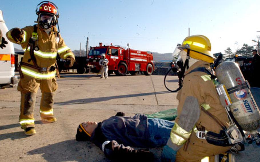Firemen treat a "casualty" during an anti-terrorism exercise at Camp Stanley on Tuesday.