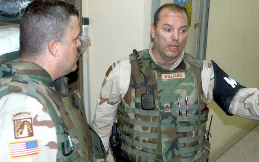 Capt. William Allen Jr., left, listens as Staff Sgt. Ken Williams briefs him about a mortar attack at LSA Anaconda.