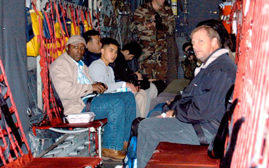 Role-playing noncombatants await the rest of the "evacuees" in the C-130.