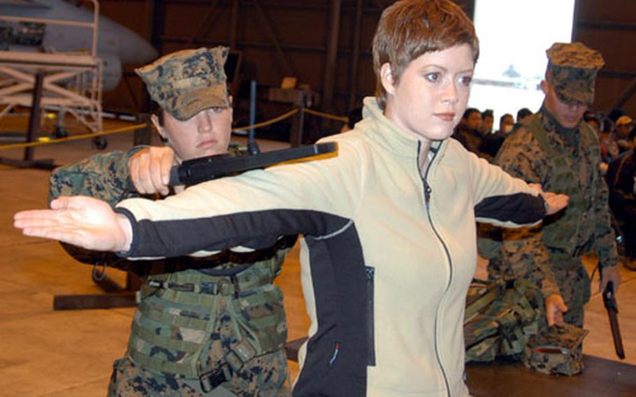 Lance Cpl. Beth Grauer scans "evacuee" Lance Cpl. Lydia Davey for contraband at one of the Evacuation Control Center stations during Thursday&#39;s NEO portion of Keen Sword 2005.