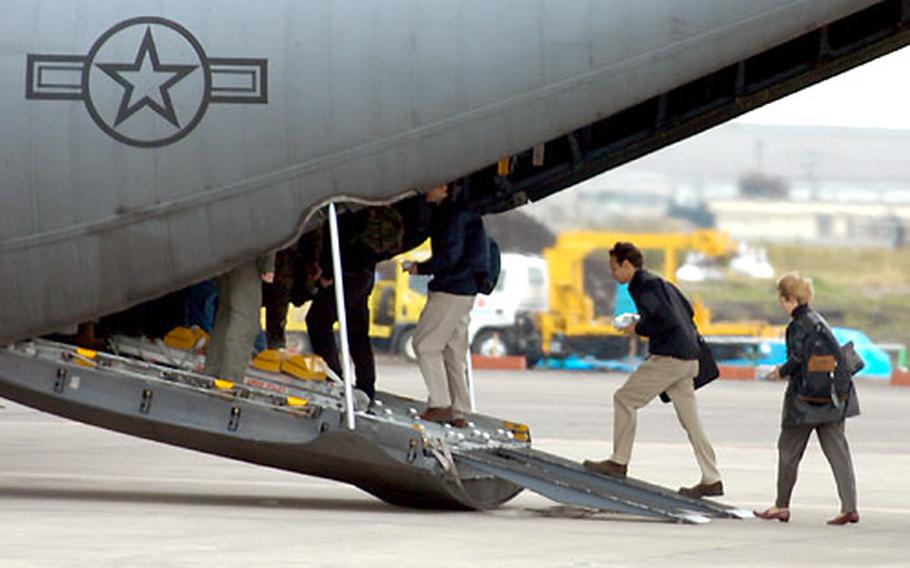 "Evacuees" make their way up the loading ramp of the C-130 bound for Tsuiki Air Base on Kyushu.