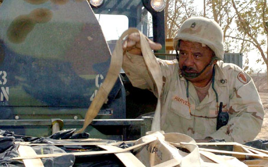 Sgt. 1st Class Marshall Harvest, 193rd Aviation Company, 185th Aviation Brigade straps a pallet of backpacks to a forklift to transport it to the airfield at LSA Anaconda. The pallets will then be transported by the brigade&#39;s aircraft to units throughout Iraq for delivery to Iraqi schoolchildren.