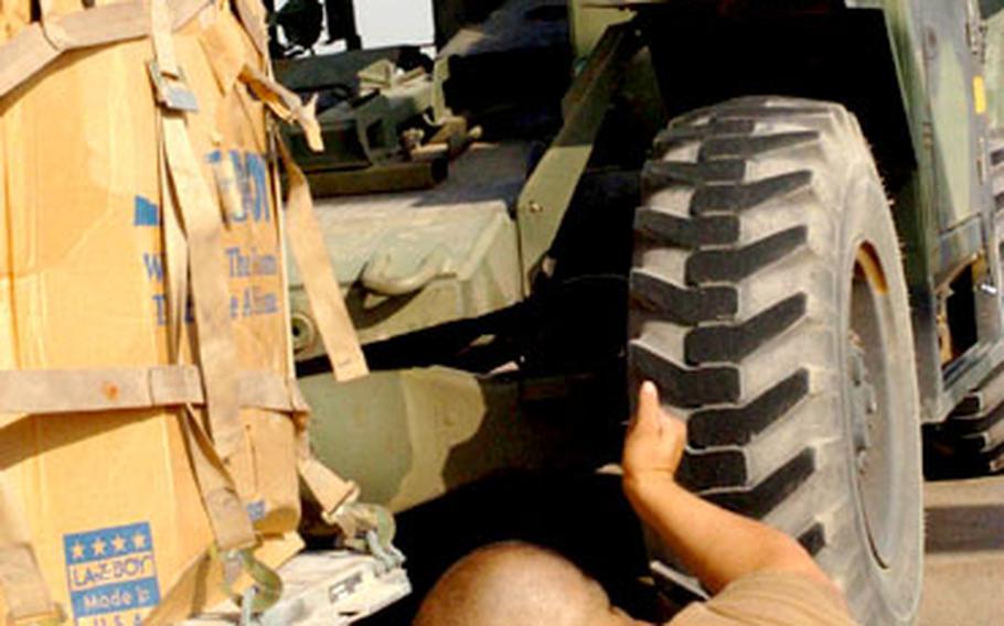 Sgt. Brandon Adriano, 193rd Aviation Company, guides a pallet of backpacks onto a CH-47 Chinook helicopter at Logistics Support Area Anaconda for delivery to units at Forward Operating Base Speicher.