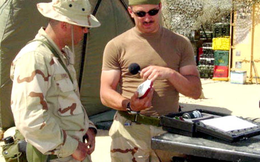 Petty Officer 2nd Class Scott Gervasi, right, of Navy Environmental and Preventive Medicine Unit 7, explains the operation of a sound meter to another sailor.