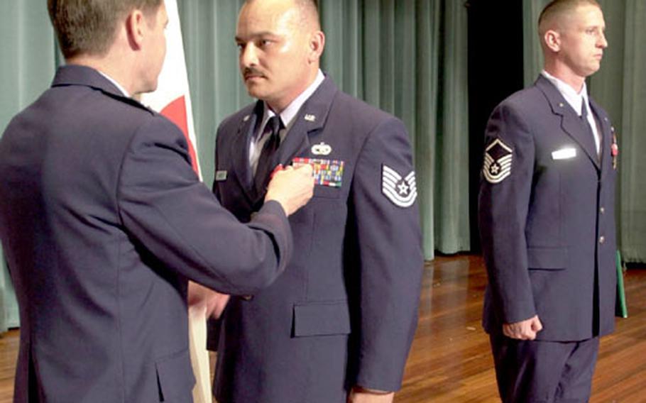 Brig. Gen. Jan-Marc Jouas, left, commander of the 18th Wing, pins the Bronze Star on Tech. Sgt. William Dominy, while Master Sgt. Jonathan Tucker stands nearby after receiving the same award during a ceremony Wednesday at Kadena Air Base, Okinawa.