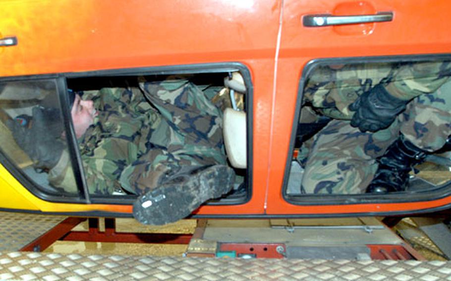 Soldiers from Company D, 1st Battalion, 4th Infantry Regiment, try to escape a rolled over car Tuesday at Hohenfels, Germany. The event showed soldiers how difficult it is to escape from a vehicle while upside-down.